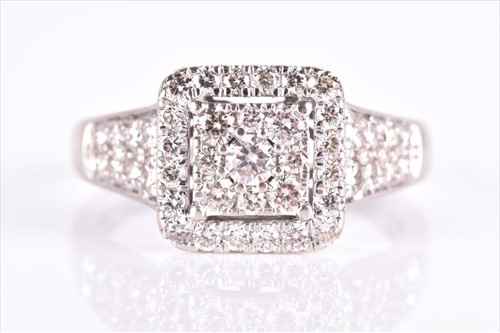 Lot 527 - A diamond cluster dress ring set with a...