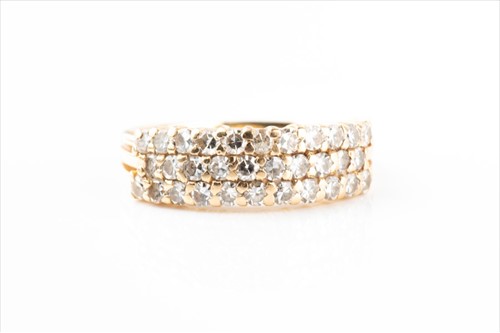 Lot 402 - A yellow metal and diamond band ring set with...
