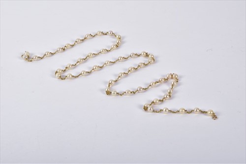 Lot 639 - An opera length pearl necklace with yellow...