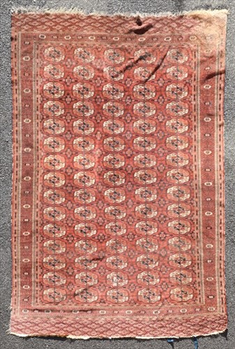 Lot 70 - A Bokara red ground carpet the central field...
