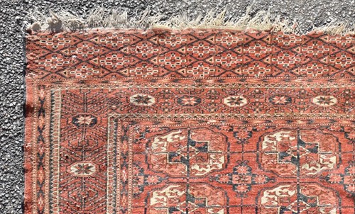 Lot 70 - A Bokara red ground carpet the central field...