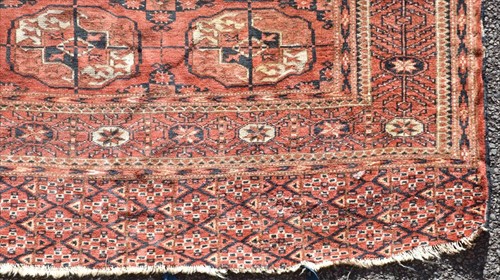 Lot 70 - A Bokara red ground carpet the central field...