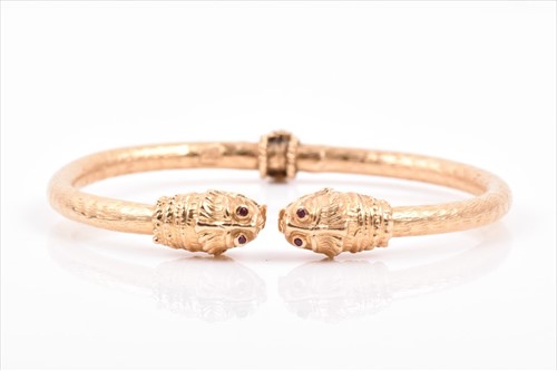 Lot 504 - A yellow metalÂ bangle in the style of Ilias...