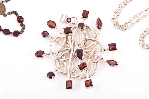 Lot 508 - A silver and garnet Modernist style pendant...