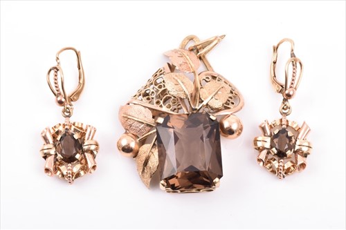 Lot 487 - A yellow metal mount smokey quartz pendant set...