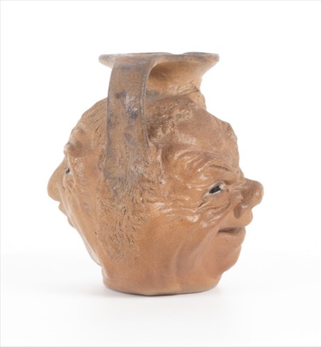 Lot 223 - A Martin Brothers double-sided stoneware face...