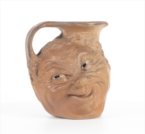 Lot 223 - A Martin Brothers double-sided stoneware face...