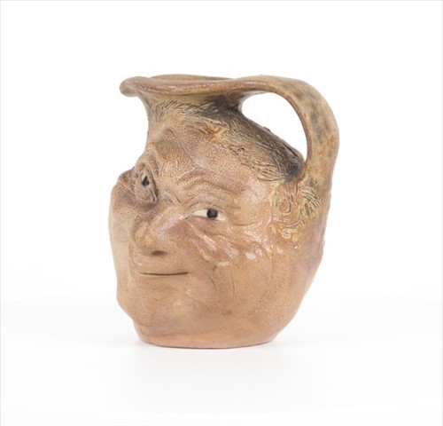 Lot 205 - A Martin Brothers double-sided stoneware face...