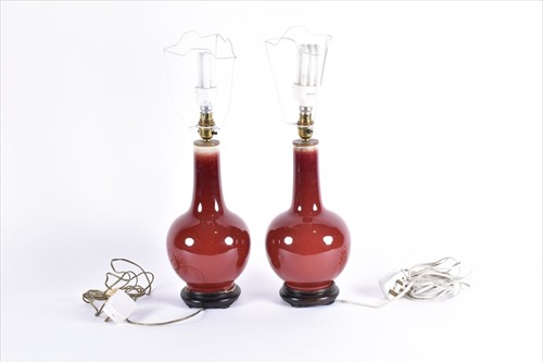 Lot 179 - A pair of Chinese sang de boeuf ceramic lamps...