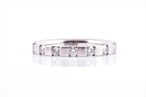 Lot 634 - A platinum and diamond eternity ring by...