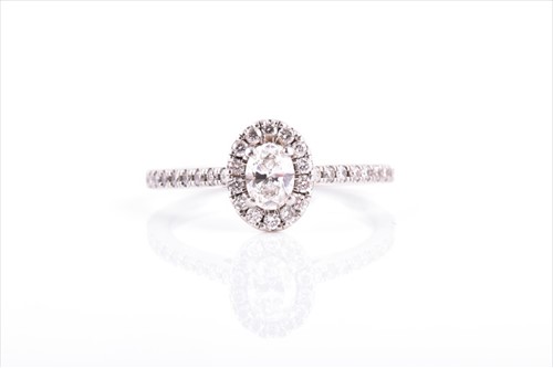 Lot 564 - A platinum and diamond ring of oval cluster...