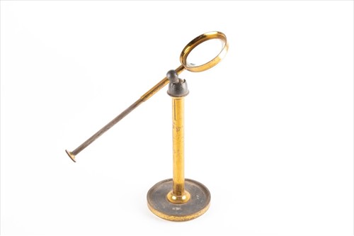 Lot 242 - A late 19th century brass table magnifier with...