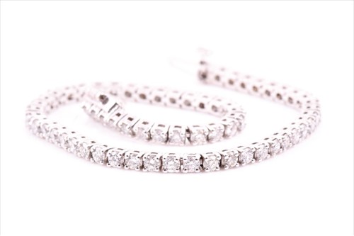 Lot 733 - An 18ct white gold and diamond line bracelet...