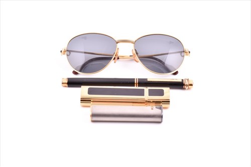 Lot 561 - A pair of Cartier sunglasses in original red...