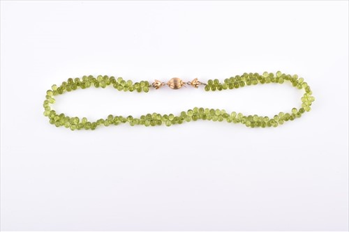 Lot 525 - A faceted peridot bead necklace comprised of...