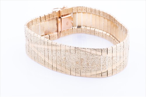Lot 569 - A yellow metal flat-link articulated bracelet...