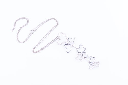 Lot 523 - An 18 carat white gold and diamond pendant in...