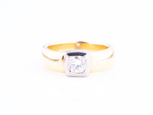 Lot 466 - A diamond solitaire ring in yellow and white...