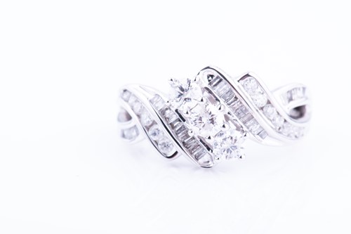 Lot 374 - A white metal and diamond crossover ring,...