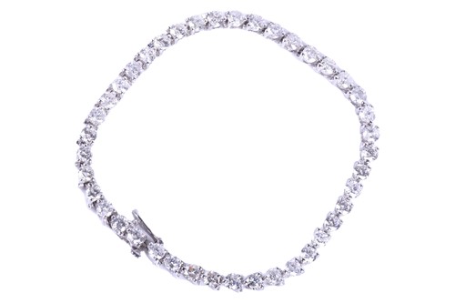 Lot 396 - A 14k white gold and diamond line bracelet,...