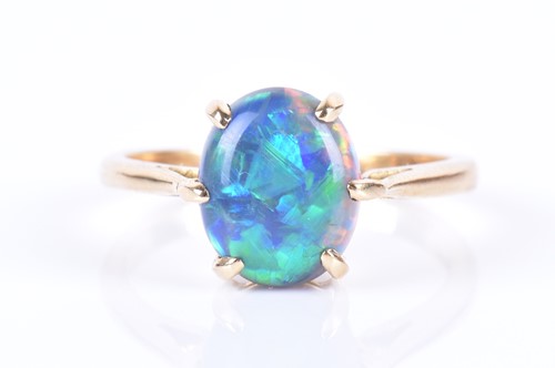 Lot 13 - An 18ct yellow gold and opal ring set with an...