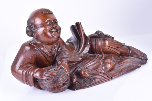 Lot 547 - A Chinese carved wooden model of a reclining...