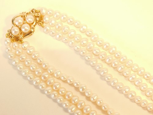 Lot 357 - A three strand pearl choker necklace, with...