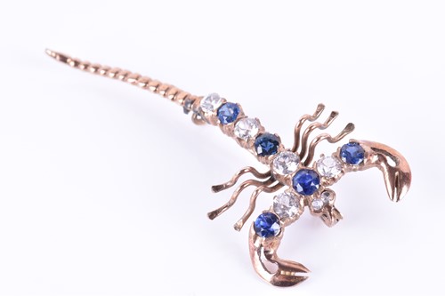 Lot 112 - A yellow metal, blue and white sapphire brooch...