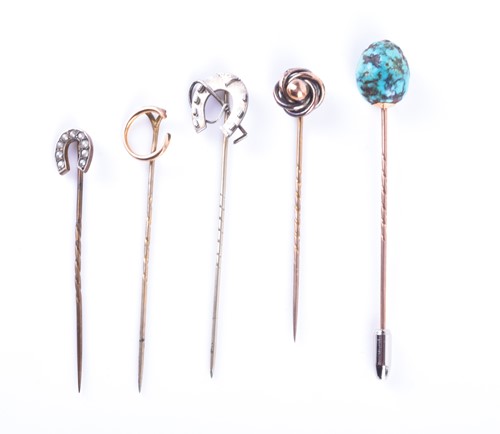 Lot 825 - A group of four yellow metal stick pins...