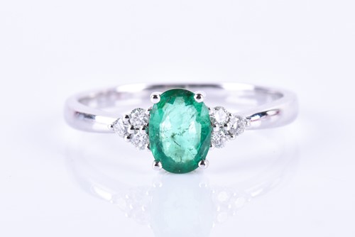 Lot 675 - A 14k white gold, diamond, and emerald ring,...