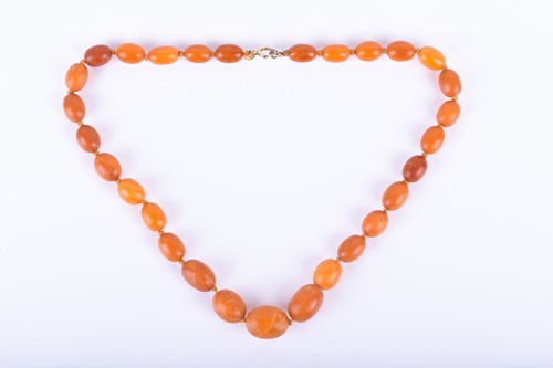 Lot 853 - A butterscotch amber necklace largest bead 2 x...