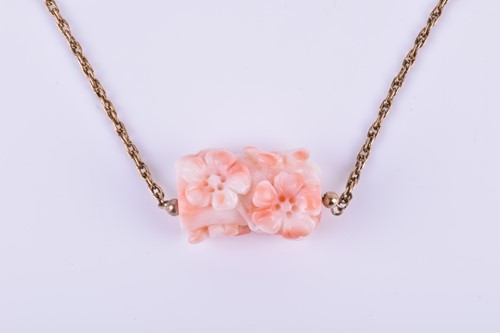 Lot 783 - A carved coral pendant decorated with flowers...