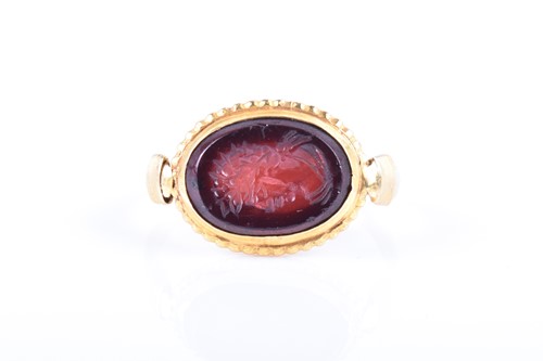 Lot 672 - A yellow metal and carved intaglio ring, inset...