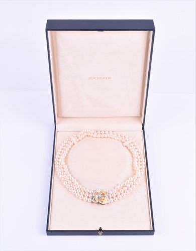 Lot 690 - A Bucherer Akoya triple strand pearl necklace,...