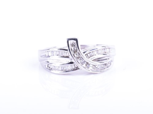 Lot 874 - A white metal and diamond crossover style ring...