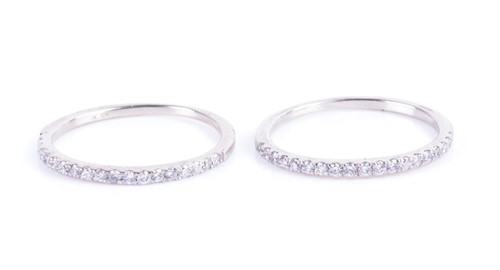 Lot 665 - A pair of white gold and diamond half eternity...