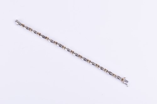 Lot 770 - A white and yellow metal and diamond line...