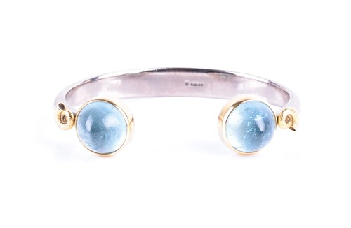 Lot 800 - An 18ct white gold and aquamarine bangle the...
