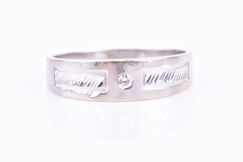 Lot 756 - A white metal and diamond gents ring, centred...