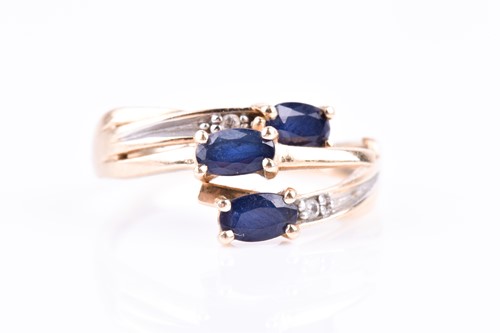 Lot 283 - A yellow metal and triple sapphire crossover...