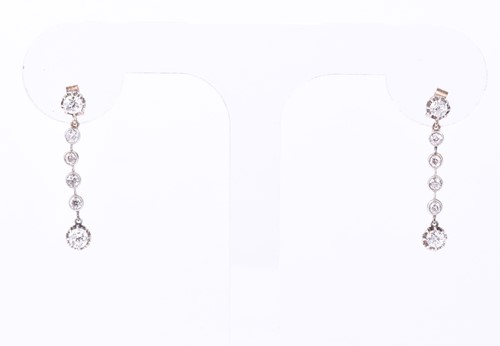Lot 810 - A pair of diamond pendant earrings, the six...
