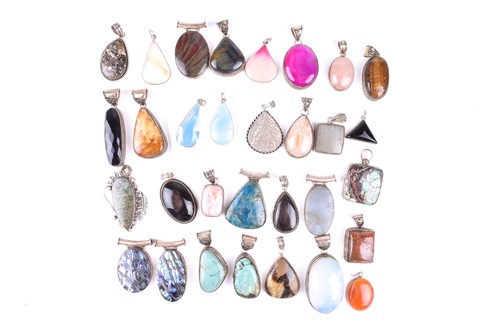 Lot 527 - Thirty hardstone pendants in white metal...