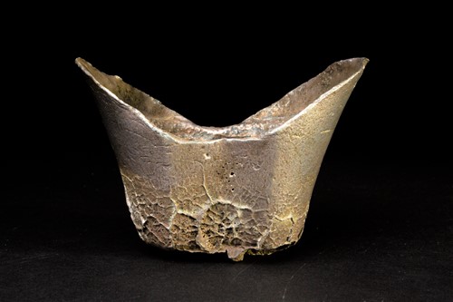 Lot 104 - A Chinese sycee silver ingot of abstract boat...