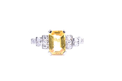 Lot 634 - A platinum, diamond, and yellow sapphire ring...