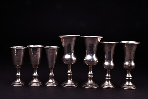 Lot 559 - A set of three silver tots, 8.4 cm high,...