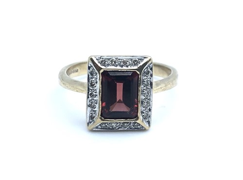 Lot 764 - A 9ct yellow gold, diamond, and garnet ring,...
