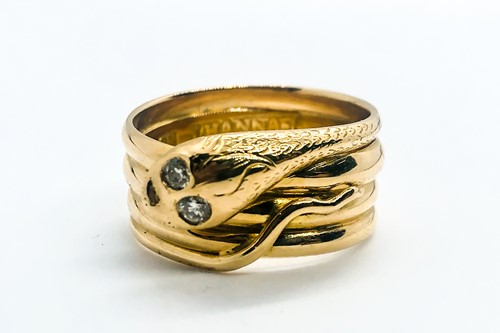 Lot 769 - An unusual yellow metal snake ring, the curled...