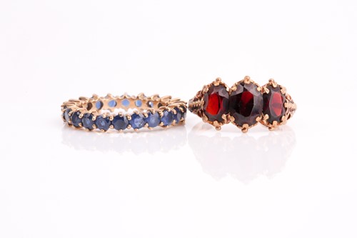 Lot 25 - A three stone half hoop garnet ring, the...