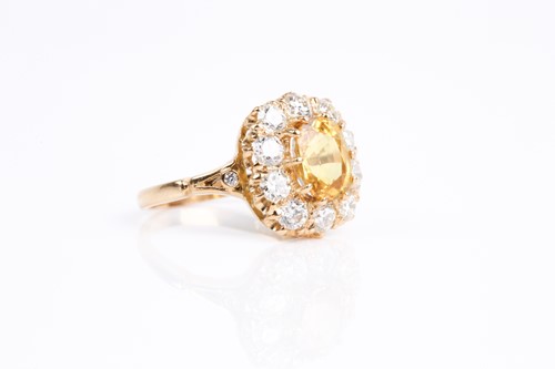 Lot 68 - A yellow sapphire and diamond cluster ring,...