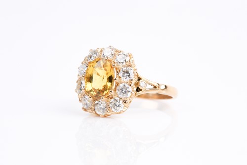 Lot 68 - A yellow sapphire and diamond cluster ring,...